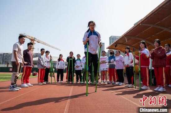 3月19日，香港学生体验少数民族传统体育项目《高跷》。唐哲 摄