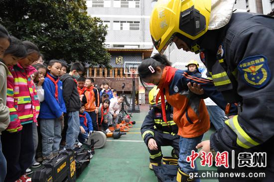 3月21日，贵阳市南明区达德学校（二校区）的学生在消防指战员的指导下体验消防装备。