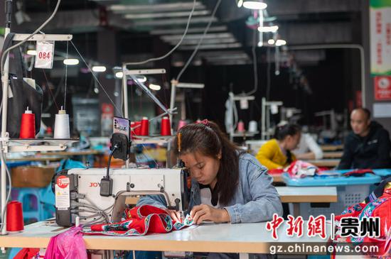 2024年3月25日，贵州省从江祖英刺绣有限公司的工人在服装生产车间赶制订单产品。