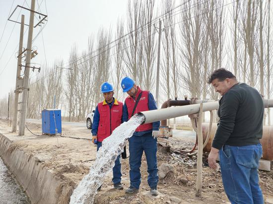 3月22日，国网阿克苏供电公司员工在温宿县古勒阿瓦提乡二大队检查用户机井用电情况。赵二安 摄