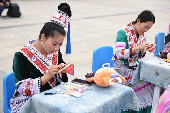 3月30日，首届贵州牛肉粉文化旅游季系列活动上，来自黔西市各乡镇的百名绣娘妇女儿童缝制吉祥物绣“福牛”，向观众和游客展现少数民族的文化魅力。