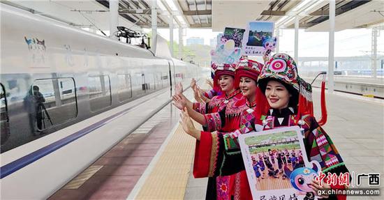 3月29日，都安县文艺志愿者在贵南高铁冠名列车首发站台唱响迎客歌。高东风  李雪松  摄影报道