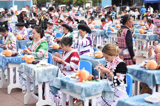 3月30日，首届贵州牛肉粉文化旅游季系列活动上，来自黔西市各乡镇的百名绣娘妇女儿童缝制吉祥物绣“福牛”，向观众和游客展现少数民族的文化魅力。