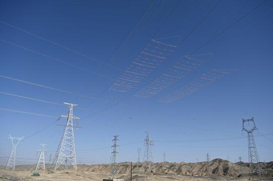 3月27日，巴州—铁干里克—若羌750千伏输电线路工程跨越施工现场，展放的导线从防护网上方顺利通过。马元 摄