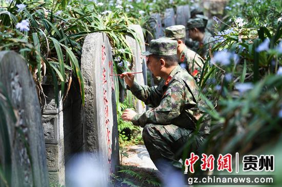 4月3日，在贵阳市南明区“铸魂·2024·清明祭英烈”祭扫活动现场，人武部工作人员正为凤山革命烈士陵园内的烈士碑文描红。