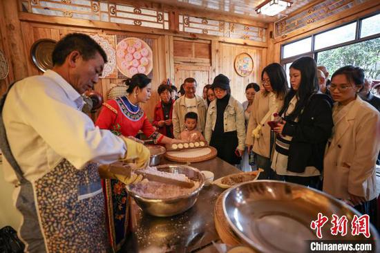 4月4日，游客在龙潭古寨仡佬特色美食工坊观看“酥食”制作。　中新社记者 瞿宏伦 摄