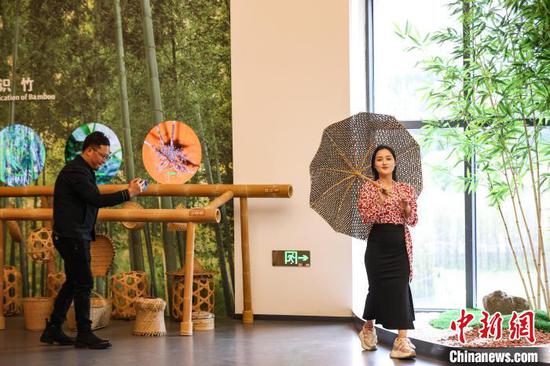 4月8日，参观者拿着“竹伞”拍照打卡。中新网记者 瞿宏伦 摄