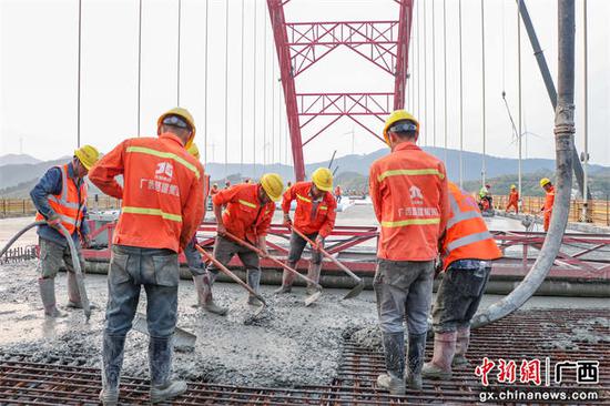 劳务工人进行主桥桥面混凝土铺装。 罗雄鹰  摄