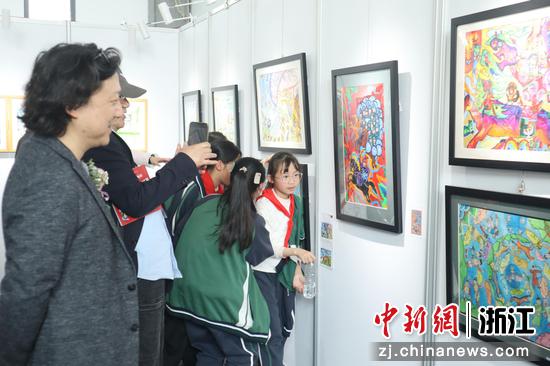 艺术家和当地小学生们在参观画展。黄彦君 摄