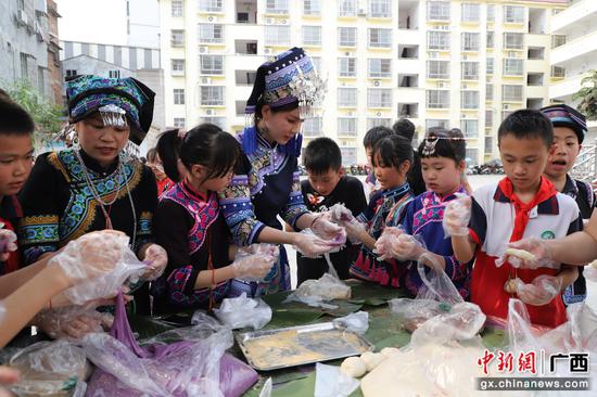 4月10日，在广西田林县第一小学，师生共同制作传统美食。