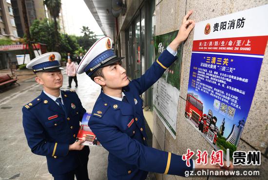 4月11日，贵阳市南明区消防救援大队的消防员正在花果园大街C区张贴电动自行车火灾防控宣传海报。