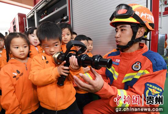 4月11日，贵阳市南明区消防救援大队后冲路消防救援站的消防员正在给小朋友们介绍泡沫水枪的使用方法。