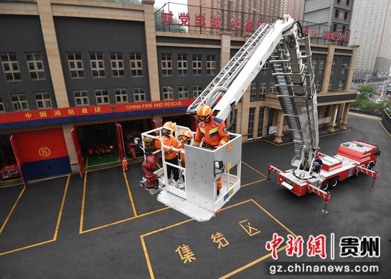 4月11日，在贵阳市南明区消防救援大队后冲路消防救援站，小朋友们正在消防员的帮助下体验乘坐51米登高平台消防车。