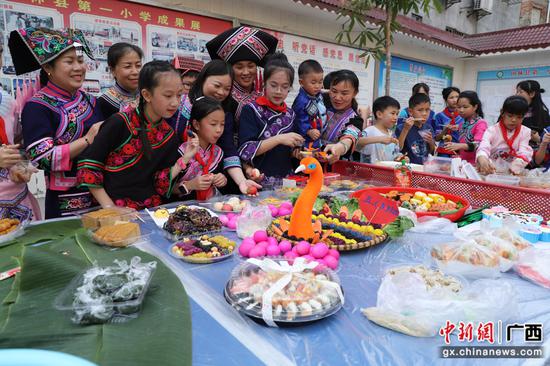 4月10日，在广西田林县第一小学，师生共同欣赏精美美食作品。