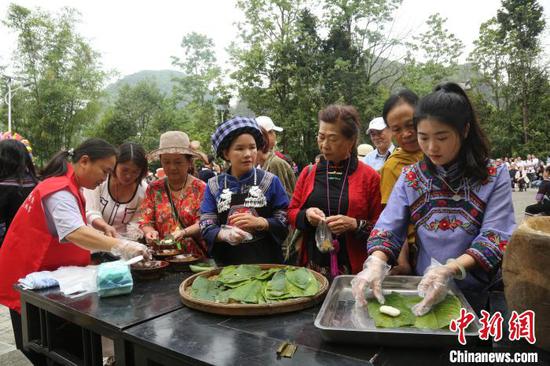 图为贵州册亨大寨村布依群众欢庆传统节日“三月三”，外地游客品尝美食。叶方杰 摄