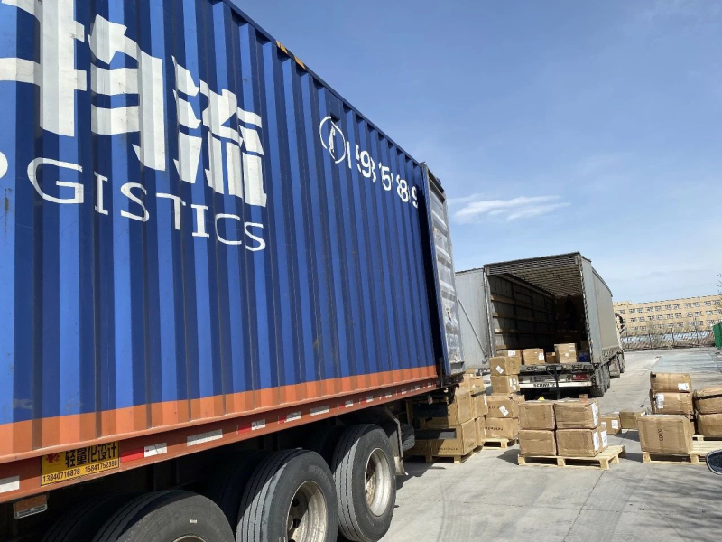 在博乐边境经济合作区海关监管仓，中国和俄罗斯的物流车辆正在进行小商品“交接”。  记者胡义华 摄
