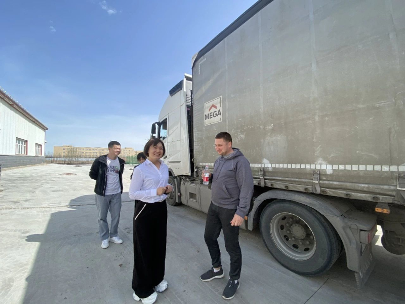 在博乐边境经济合作区海关监管仓，俄罗斯司机皮欧特（右一）正在与工作人员交流。  记者胡义华 摄 
