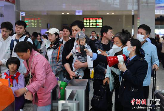 图为桂林火车站客运工作人员为旅客答疑解惑。郑长贤 摄