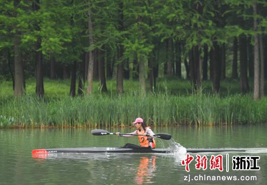 选手在西溪湿地优美的环境中参加皮划艇女子公开组比赛。中新社记者 王刚 摄