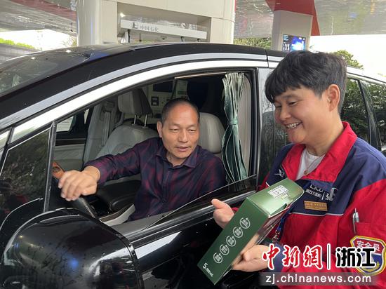 萧山机场站员工徐国美为顾客展示燃油宝。丁婧 供图