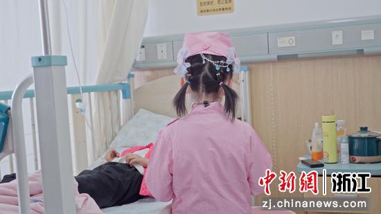 唐欣鸿在医院安慰其他肿瘤儿童。何松霖 供图