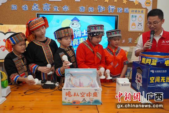广西贺州市八步区黄洞瑶族乡民族学校的同学们排队体验电的产生。蓝淑娴 摄