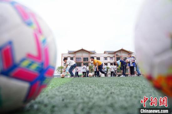 在贵州省从江县贯洞镇第二小学，足球社团的学生在课后服务时间进行足球训练。卢忠南 摄