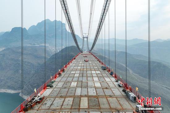 牂牁江大桥是纳晴高速重点控制性工程之一，地处贵州晴隆、普安、水城、六枝等4县(区)的交界处，横跨牂牁江，为双塔单跨钢桁梁悬索桥，全长1849米，主跨1080米，桥面至江面最高距离380米，桥梁高度在世界百座高桥中排名第12位。
图为4月28日，航拍合龙后的牂牁江大桥。中新网记者 瞿宏伦 摄