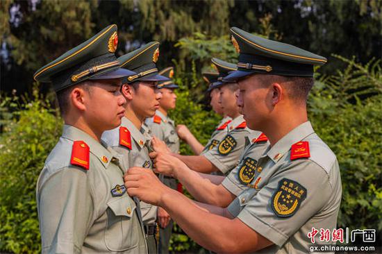 4月29日，武警官兵党员代表及老团员代表正在为新团员佩戴团徽。贾广华 摄