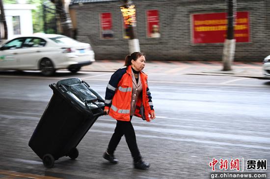 5月1日，一名环卫工人正在贵阳市南明区箭道街清理生活垃圾。
