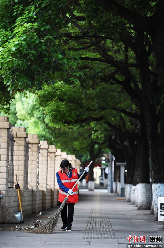 5月1日，环卫工人在贵阳市南明区瑞金南路的人行道上清扫保洁。