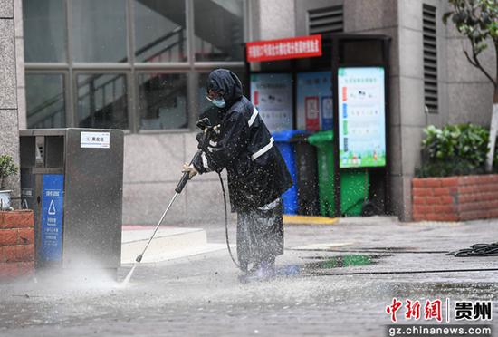 5月1日，在贵阳市南明区兴隆街一小区内，一名保洁员正在冲洗路面。