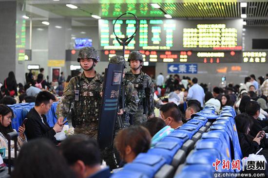 5月1日，武警贵阳支队南明中队官兵在贵阳火车站站前广场巡逻警戒，确保旅客平安出行。