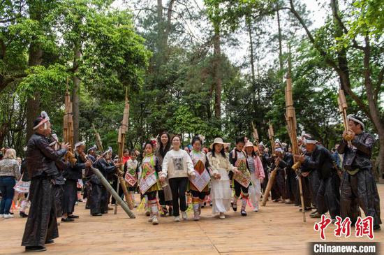 游客与村民在贵州省从江县丙妹镇岜沙苗寨景区一起跳芦笙团结舞。吴德军摄