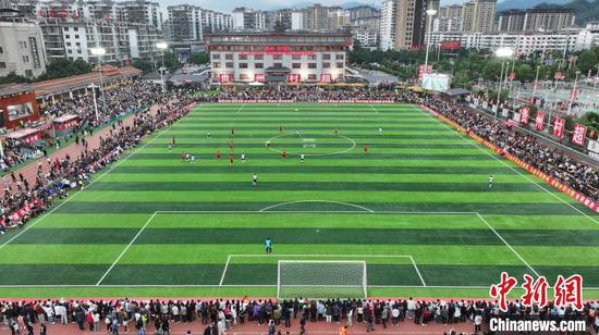 5月1日，航拍辽宁东港草莓足球队球员与利比里亚社联足球队球员在贵州“村超”球场进行拼抢。韦贵金摄