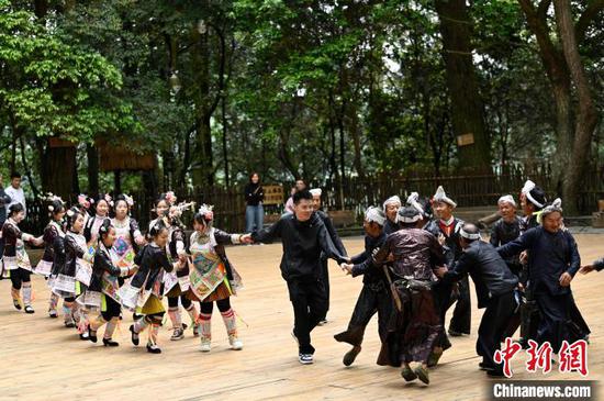 一名游客在贵州省从江县丙妹镇岜沙苗寨景区参与婚俗表演。吴德军摄