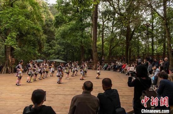 游客在贵州省从江县丙妹镇岜沙苗寨景区观看表演。吴德军摄