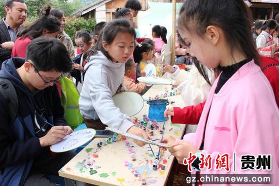 图为小朋友们在文化街“国风市集”画扇。王秋旭摄 图为小朋友们在文化街“国风市集”画扇。王秋旭摄
