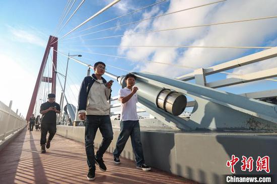 图为游客在龙里河大桥上游览。中新网记者 瞿宏伦 摄