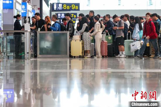 图为旅客在贵阳北站排队检票。中新网记者 瞿宏伦 摄