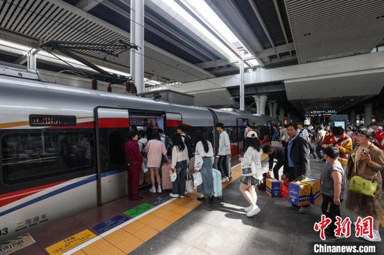 图为旅客在贵阳北站月台登车。中新网记者 瞿宏伦 摄