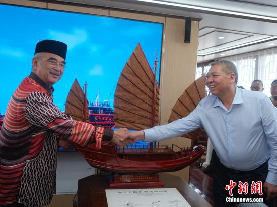 当地时间5月5日，正在马六甲交流的最大仿古福船“福宁”号受到马来西亚各界关注。图为马六甲州元首穆罕默德（左）5日抵“福宁”号参观，并获赠“福宁”号模型。中新社记者 陈悦 摄