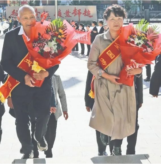 2019年,参加中华人民共和国成立70周年国庆系列庆祝活动的九师代表魏德友、梅莲载誉归来(资料图片)。高剑平 摄 2019年,参加中华人民共和国成立70周年国庆系列庆祝活动的九师代表魏德友、梅莲载誉归来(资料图片)。高剑平 摄