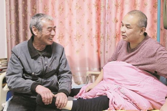 张忠敏（左）为张建成按摩，陪他聊天（摄于12月10日）。叶香香 摄