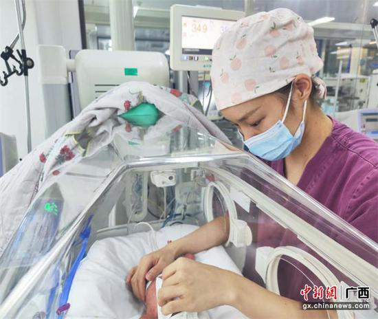 图为新生儿科护士为新生儿进行皮肤护理。黄玲 摄