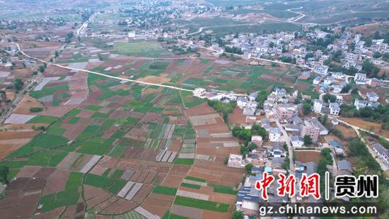 贵州省毕节市威宁自治县中水镇早熟种植地块与村庄、桥梁、道路相互映衬，犹如一幅画卷。（航拍图）