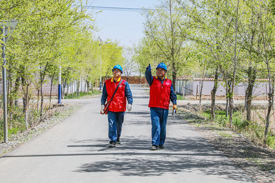 4月30日，吳新瑞和同事在北庭鎮(zhèn)三場槽子牧業(yè)新村檢查供電線路。（李文濤 攝）