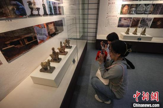 5月17日,参观者在拍摄播州杨氏土司考古成果展展出的明代土陶俑。中新网记者 瞿宏伦 摄 5月17日,参观者在拍摄播州杨氏土司考古成果展展出的明代土陶俑。中新网记者 瞿宏伦 摄