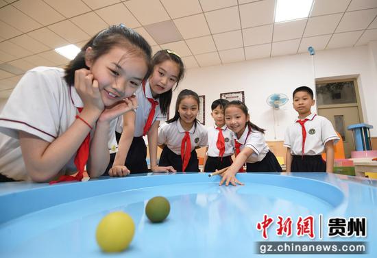 5月28日，贵阳市南明区花果园第三小学的同学们正在校园科技馆内体验“神奇的椭圆”。