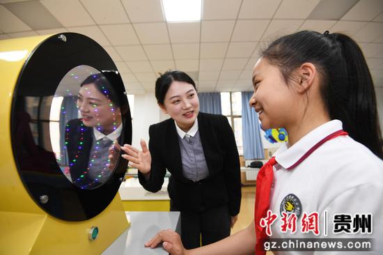 5月28日，在贵阳市南明区花果园第三小学校园科技馆内，一名学生在老师人指导下体验“窥视无穷”。